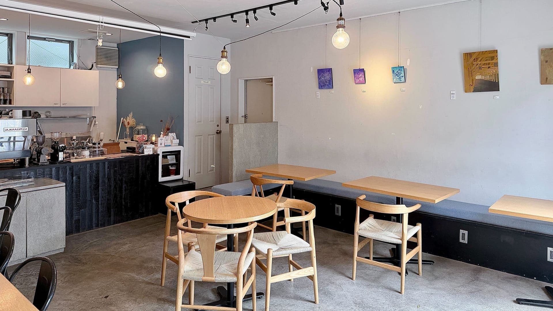 kolm 店内 — テーブルと椅子、壁に飾られたアート作品