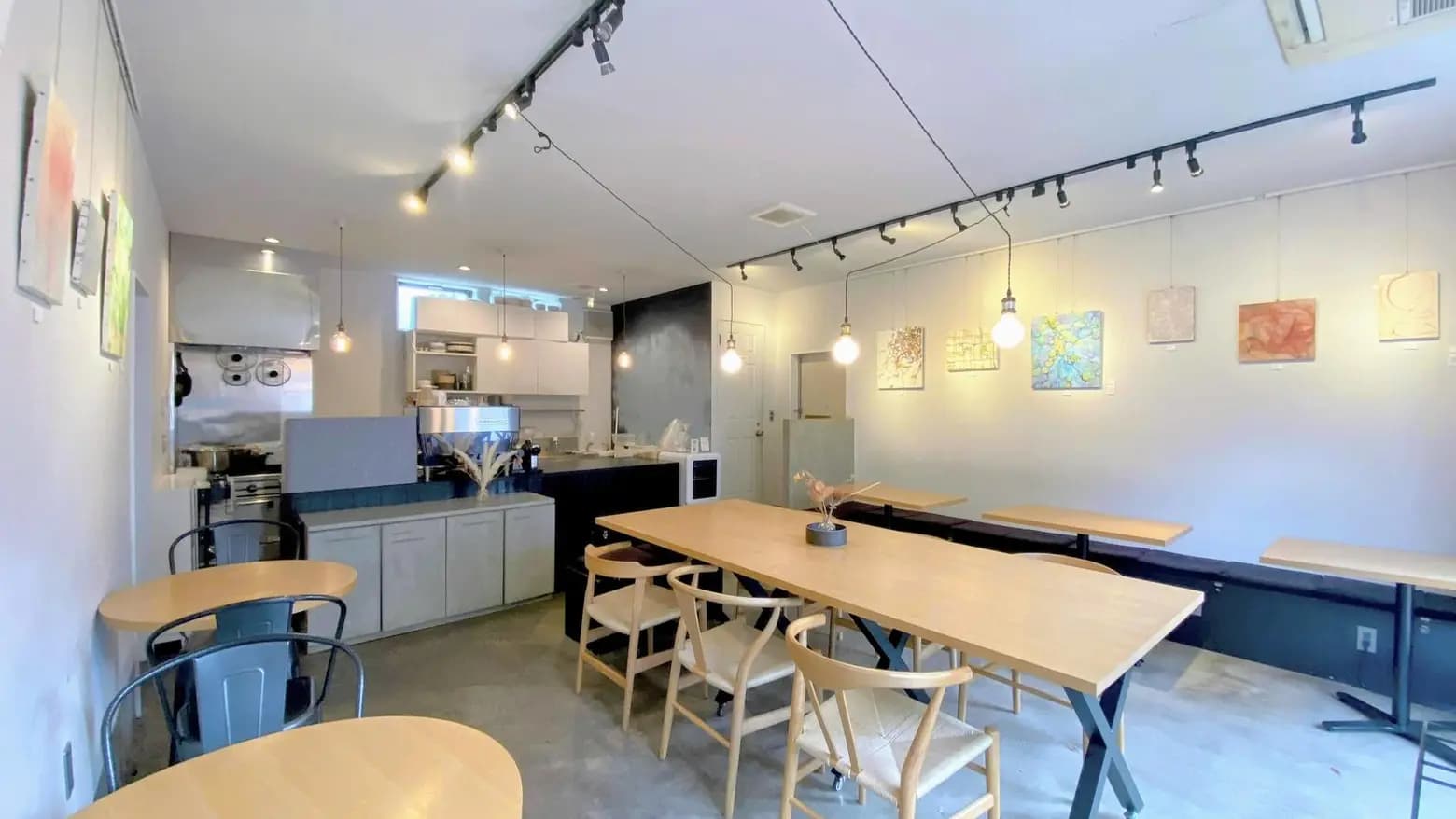 kolm 店内 — 白い壁にアート作品が並ぶ、明るい空間